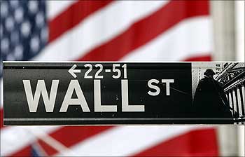 A Wall Street sign is seen in front of the New York Stock Exchange.