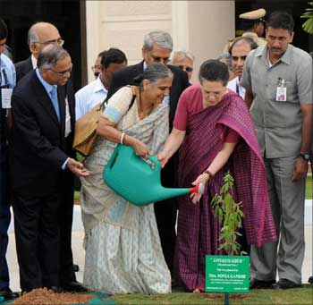Sudha Murthy helps Sonia Gandhi to water a plant.