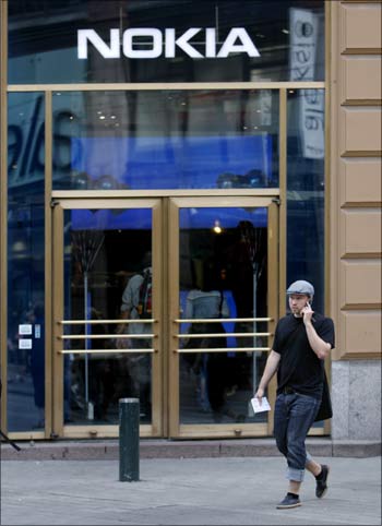 A man talking on his mobile phone walks past Nokia's flagship store in Helsinki.