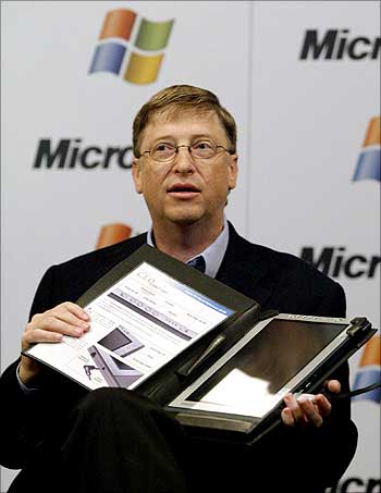 Bill Gates holds up a Tablet PC while speaking at a press conference.