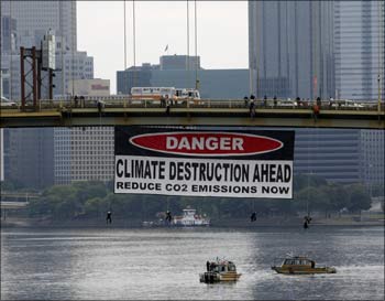 Greenpeace activists hang from a large banner on a bridge near the site of the upcoming G20 Pittsburgh Summit in Pittsburgh.