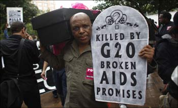 A protestor carries a mock coffin as he demonstrates with a group of AIDS activists holding a funeral procession near the site of the upcoming G20 Pittsburgh Summit in Pittsburgh.
