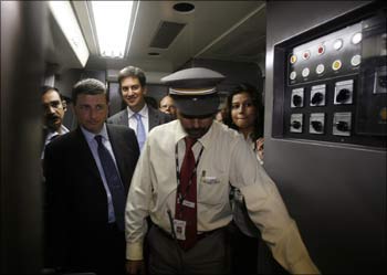 Britain's International Development Minister Douglas Alexander (2nd from left) and Energy and Climate Change Minister Ed Miliband (3rd left) walk inside the driver's cabin of the Delhi Metro Rail Corporation in New Delhi.