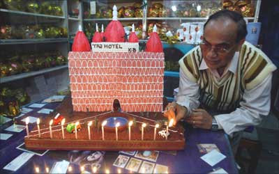 A shopkeeper places candles on the model of a cake in Siliguri, West Bengal.