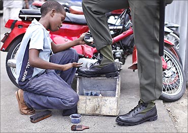 A child polishes military boots in a street in Santo Domingo.