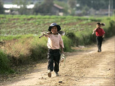 Children carry their tools as they leave the field at the end of the day in Tecpan, Guatemala.