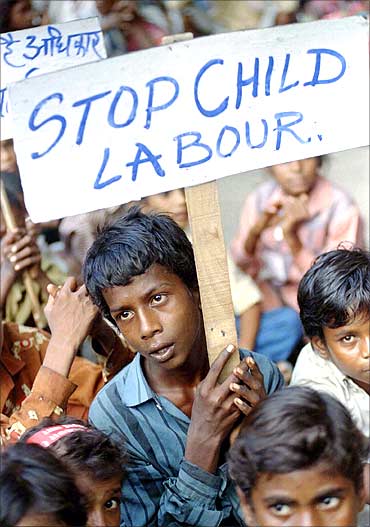 Radhaysham, 13, an Indian child labourer carries a placard during a rally.