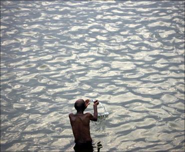 A man prays while standing in the river Ganga in Varanasi