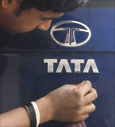 A worker cleans a vehicle of Tata Motors inside a showroom in Hyderabad.