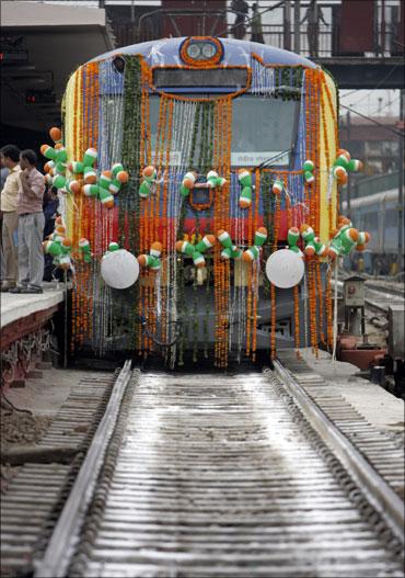 People stand near a decorated train.