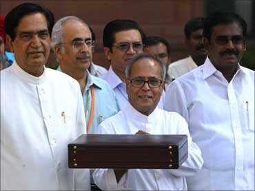 Finance Minister Pranab Mukherjee (C) smiles as he leaves his office to present the 2009/10 Union Budget in New Delhi.