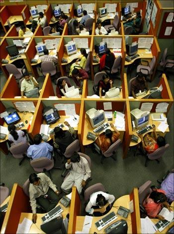 Indian employees seated in their cubicles at a call centre.