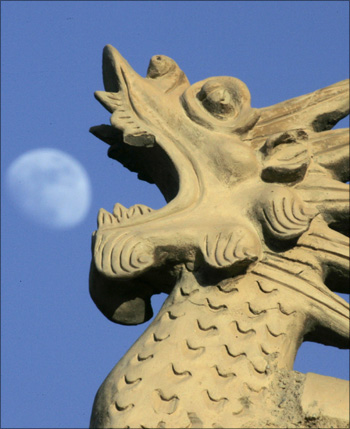 Image: A traditional Chinese architecture style dragon head is seen as the moon rises at the Jiayuguan Pass Town in Jiayuguan in northwest China's Gansu province. Photograph: Jason Lee/Reuters