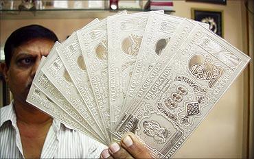 A jeweller displays silver plates in the form of Indian rupee notes in Chandigarh.