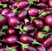 Customers purchase brinjals at a wholesale vegetable market in Mumbai.