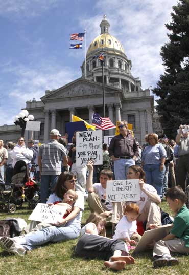 A family holds signs at a tea party protest on the grounds of the Colorado State capitol in Denver