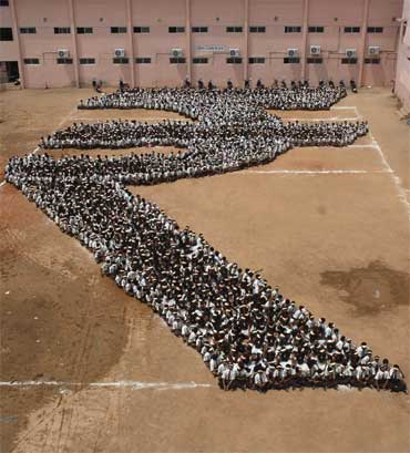 Students make a formation of the new symbol of the Indian rupee at a school in Chennai on July 16, 2010.