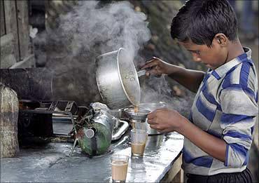 A child works at a roadside teastall.