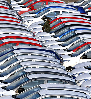 An employee checks parked Hyundai cars ready for shipment at a port in Chennai.
