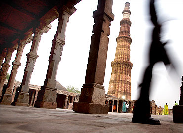 A tourist walks past the Qutab Minar in New Delhi.