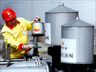 A PetroChina employee inspects oil valves at an oil storage in Suining, China.