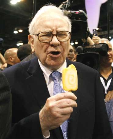 Buffett reacts after taking a bite of a Dairy Queen vanilla orange ice cream bar.