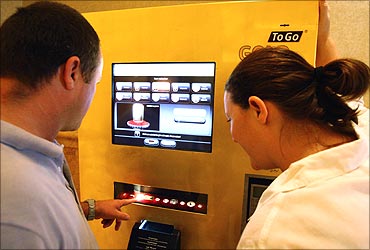 Customers use the ATM at the Emirates Palace Hotel.