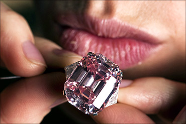 An employee poses with a 24.78 carat Fancy Intense Pink diamond at Sotheby's in Geneva.