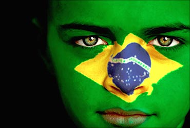A lady shows the Brazilan flag on her face.