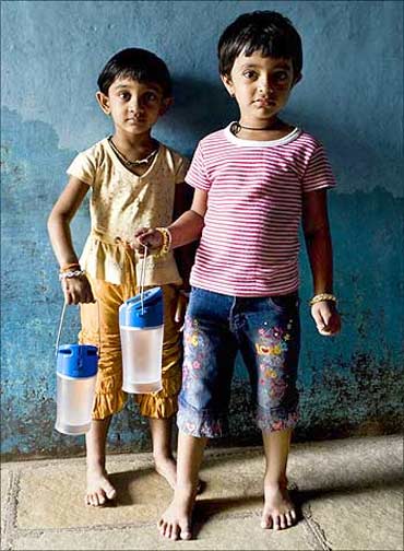 Children holding the Kiran lamp in India.