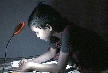 A child studies using a solar lamp.