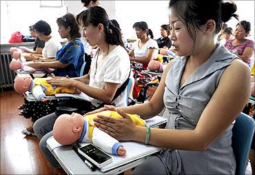 Chinese women learn baby sitting skills.