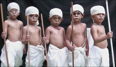 School children dressed as Mahatma Gandhi take part in a cultural programme.