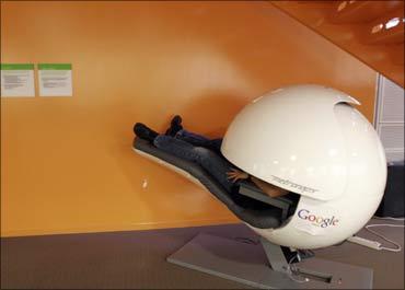 A staff takes a nap in a nap pod that blocks out light and sound at Google headquarters, California.