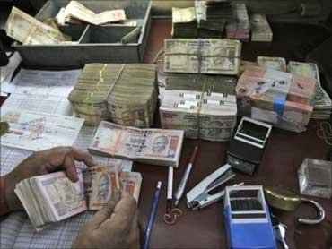 A bank staff counting Indian curremcy notes.