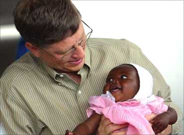 Bill Gates holds baby Cecil Massango during his visit to the Manhica Health Research Centre in Mozambique.