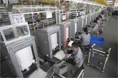 Employees work at a washing machine production line.