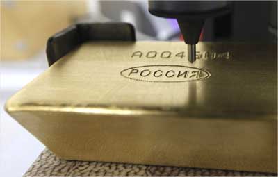 A machine engraves information on an ingot of 99.99 percent pure gold.