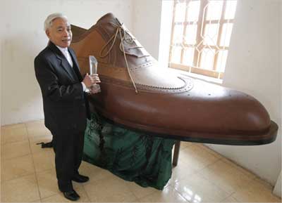 Luu Xuan Chung stands next to 2.72 metre Italian-style shoe in the handicraft village of Gie Ha.
