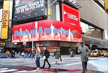 Pedestrians walk past a Bank of America sign on a building in Times Square in New York.