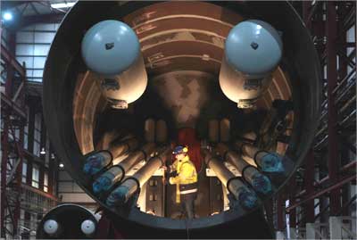 An engineer works inside a section of a Pelamis wave energy converter at their factory in Edinburgh, Scotland.