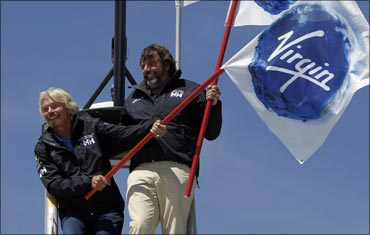 Branson (L) and Chris Welch stand on the crows nest of the Cheyenne, a 125 ft catamaran.