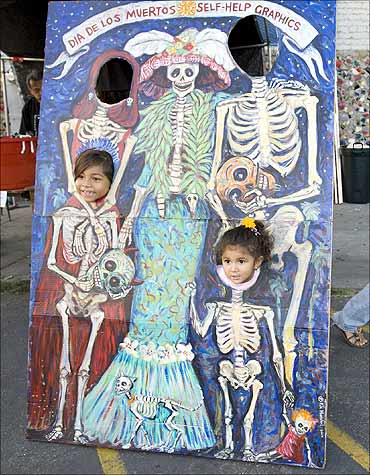 Two children have their picture taken during a celebration of the Day of the Death in Los Angeles.