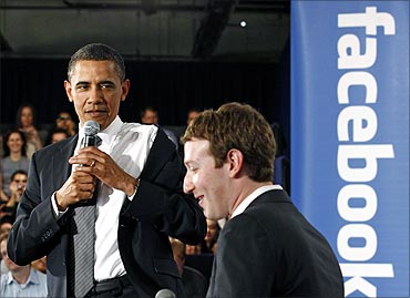 Obama takes off his jacket as he attends a town hall meeting at Facebook headquarters.