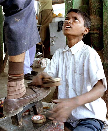 A boy polishes shoes at a suburban railway station in Mumbai.