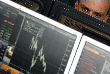 A broker monitors share prices at Newedge trading room in Zurich.