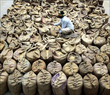 A worker prepares sacks of grain at a wholesale market at Dadri.