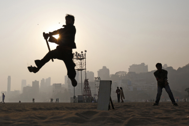 A man plays cricket by the beach in Mumbai.