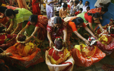 Mothers perform rituals in front of their daughters dressed as 'Kumari' during the Durga Puja festival in Siliguri.