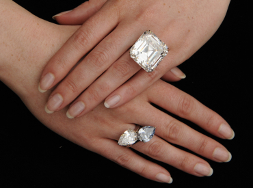 An emerald-cut white diamond, set as a ring, and a pear-shaped vivid blue diamond.